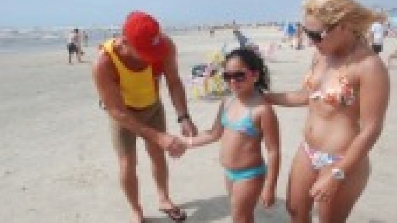 Salva-vidas distribuem pulseiras identificadoras na beira da praia