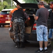 Policial faz vistoria em porta-mala de veículo abordado na 2ª Operação Integrada Metropolitana.