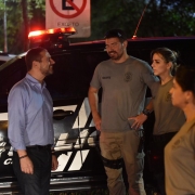 À direita, secretário adjunto da Segurança Pública, cel. Marcel Gomes Frota, conversa com quatro policiais civis, posicionados à esquerda da imagem. Ao fundo, viatura da Polícia Civil.