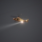 Helicóptero utilizado na 2ª Operação Integrada Metropolitana no céu com uma facho de luz.