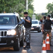 Em barreira de trânsito, dois policiais militares abordam veículos em rua da Capital.