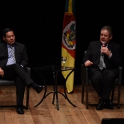 General Mourão e vice-governador Ranolfo sentados em cadeiras no palco do Teatro do Sesi. Ao fundo, bandeiras do Brasil e do RS.