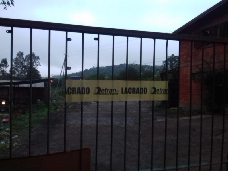Portão de estabelecimento interditado pela 83ª Operação Desmanche em Caxias do Sul, com faixa de local "lacrado".