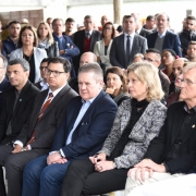 Ranolfo Vieira Júnior e Paula Mascarenhas, ao lado de outras autoridades, sentados na primeira fila de plateia do evento de inauguração de fábrica de concreto dentro do Presídio Regional de Pelotas.