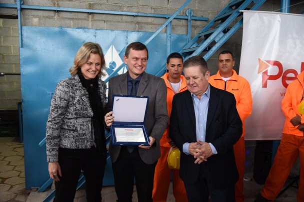 Paula e Ranolfo entregaram placa ao secretário de saúde interino e idealizador do projeto, Leandro Thurow, que aparece entre os dois, segurando a caixa com a homenagem.