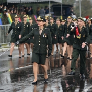 Militar feminina marcha com espada em punho à frente da tropa no Desfile de 7º de setembro em Porto Alegre. Ao lado, militar masculino toca corneta.