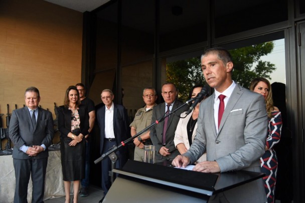 Delegado Luciano Menezes discursa em púlpito com microfone na frente do prédio revitalizado da DPPA de Santa Cruz do Sul. Ao lado, autoridades observam.