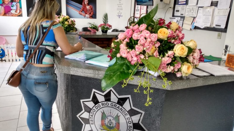 Mulheres recebem flores e mensagens de amor e autocuidado ao registrarem um boletim de ocorrência