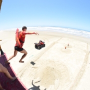 Guarda-vidas salta em direção ao solo a partir de uma guarita na praia de Tramandaí.