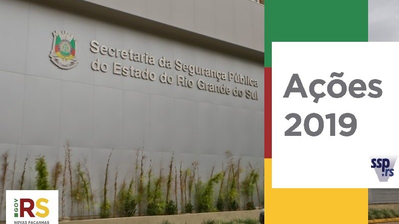 Fachada da SSP com o brasão do Estado e a inscrição "Secretaria da Segurança Pública do Estado do Rio Grande do Sul" em letras metálicas afixadas na parede. Logo do governo aplicada no canto esquerdo inferior. Quadro branco à direita onde se lê Ações 2019