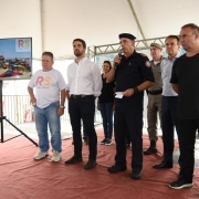 Palco montado na praia de Capão da Canoa. À esquerda, telão com tela inicial de apresentação da Operação RS Verão Total. Ao centro, o vice-governador, o governador e o comandante dos Bombeiros, cel. Bonfanti, que fala ao microfone.