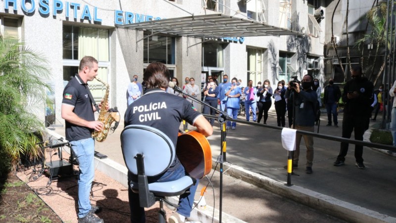 Policiais civis realizaram apresentação com voz,violão e saxofone na entrada do Hospital Ernesto Dornelles, onde profissionais de saúde observam