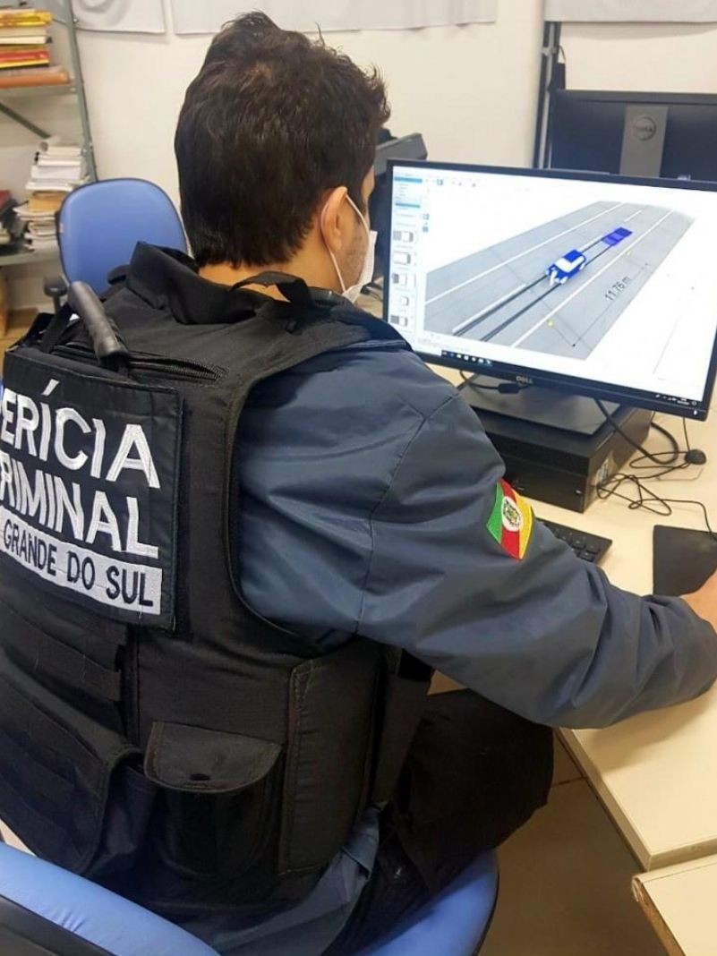Perito está sentado em frente ao computador com o software do simulador aberto para recriar condições de acidentes