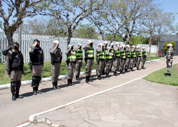 Soldados lado a lado em posição de sentido batem continência para oficial que supervisiona atividade de estágio da EsFES-POA.