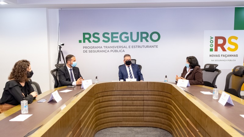sentados em uma mesa de reuniões em "u" estão a ministra Damares Alves, o vice govenador Ranolfo, o secretário adjunto da SSP e a diretora geral do IGP Heloísa Kuser.