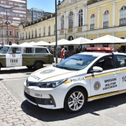 carro branco com identificação da Brigada Militar, estacionado ao lado das viaturas históricas