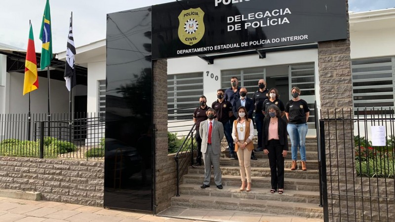 Autoridades posam para foto em escadaria abaixo de pórtico de entrada da nova Delegacia de Polícia de São Sebastião do Caí