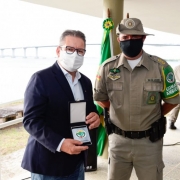 Vice-governador e Secretário de Segurança Pública, Ranolfo Vieira Júnior e Comandante interino Ten. Cel. Luciano Moritz Bueno posando para foto com comenda do batalhão.