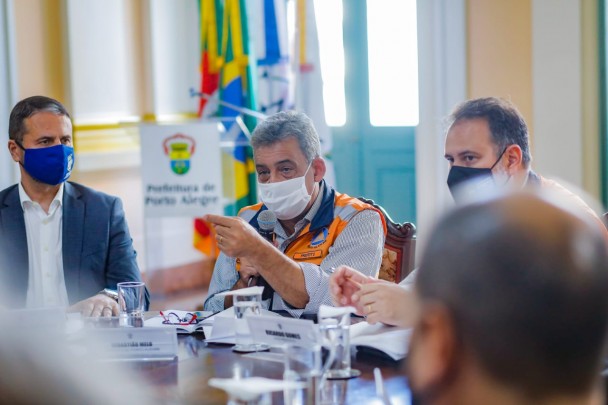 Sentados lado a lado, da esquerda para direita, o secretário adjunto da SSP, coronel Marcelo Gomes Frota, o prefeito de POA, Sebastião Melo, que fala ao microfone, o vice-prefeito da Capital.