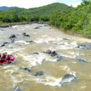 Um bote com oito bombeiros no meio de um rio.