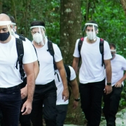 Os novos convocados caminhando portando uma mochila e utilizando máscaras e face shield de proteção contra a covid-19.