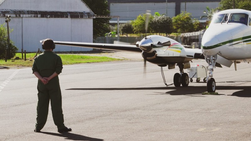 Avião da Brigada Militar sendo auxiliado por integrante das forças aéreas para a decolagem.