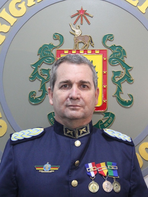 Coronel Rogério Pereira Stumpf Júnior em frente ao Brasão da Brigada Militar