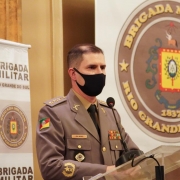 Coronel Fernando Gralha Nunes está discursando num púlpito com dois banners da Brigada Militar.
