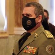 Coronel Stumpf sentado utilizando uma máscara de proteção com o logo da BM.