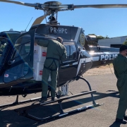 helicóptero da Polícia Civil com dois policiais da institução carregando os imunizantes