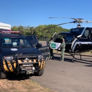 policiais civis colocando as vacinas no helicóptero para transporte aéreo