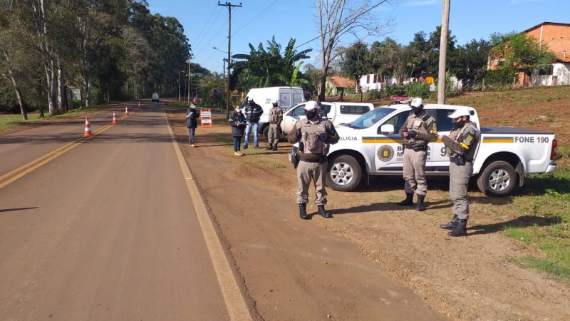 policiais militares em frente a viatura realizando barreira de fiscalização na estrada em combate aos crimes rurais