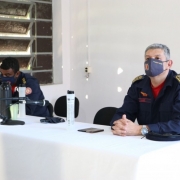 Dois oficiais sentados em frente a mesa branca.