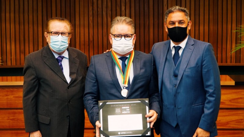 Vice Ranolfo Vieira Júnior, entre seu pai, o desembargador aposentado Ranolfo Vieira, e o procurador Marcelo Dornelles. O vice-governador está com uma medalha pendurada no pescoço e segura um quadro com um diploma.