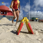 Bombeiro militar, com uniforme de guarda-vidas, em ação na praia 