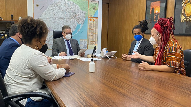 Sentados em torno de uma mesa de madeira grande de reuniões, vereadores da bancada negra da Capital e o vice-governador Ranolfo, na cabeceira. Todos usam máscaras contra Covid-19.