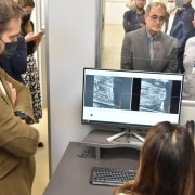 Governador Eduardo Leite, em pé, de terno marrom, observa a tela de um computador com imagem de um projétil escaneado pelo indexador balístico.