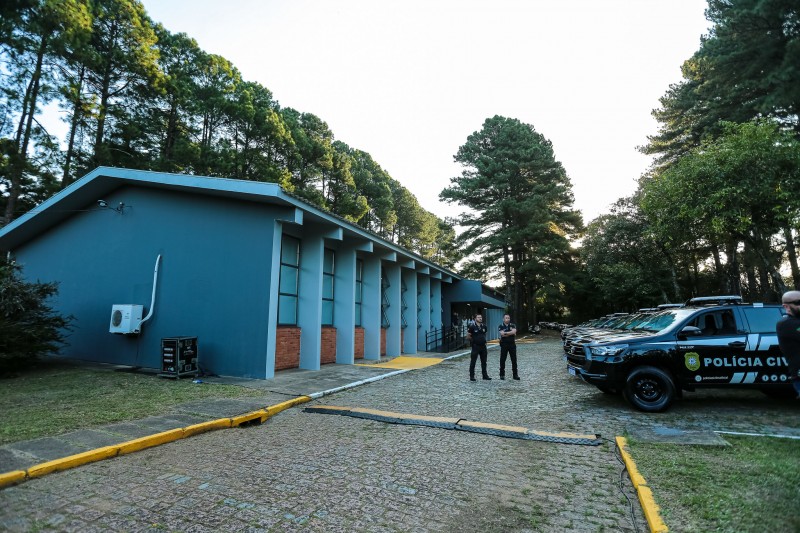 Foto mostra um dos prédios no complexo da Cidade da Polícia, diante do qual estão estacionadas várias viaturas zero quilômetro lado a lado, entregues à instituição no evento desta terça-feira (29/3).