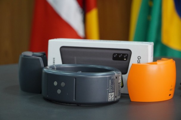 Conjunto formado por tornozeleira para o agressor e celular com o aplicativo de monitoramento para a vítima
