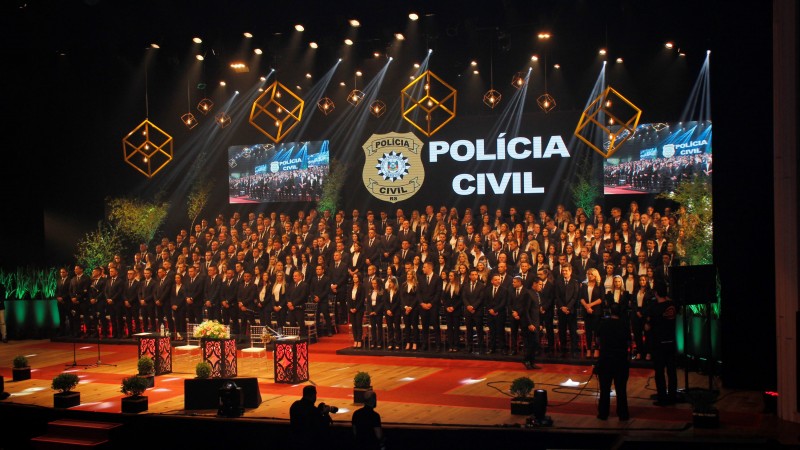 Foto retrata palco com formandos da Polícia Civil