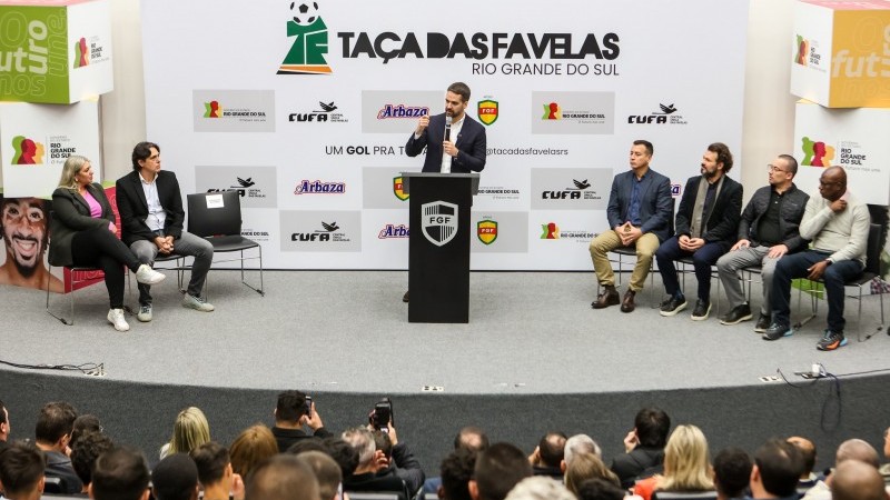 A foto mostra o governador e autoridades discursando na Ta&ccedil;a das Favelas