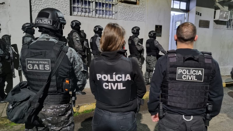 Foto mostra policiais civis em área externa.