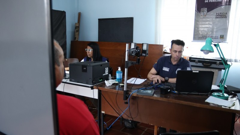Imagem de dois servidores do IGP confeccionando documentos para as vítimas das enchentes