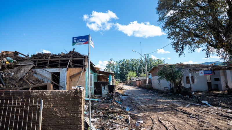 Foto mostra casas destruídas pela enchente do Vale do Taquari. Foto tirada da equina mostra rua tomada por lama.
