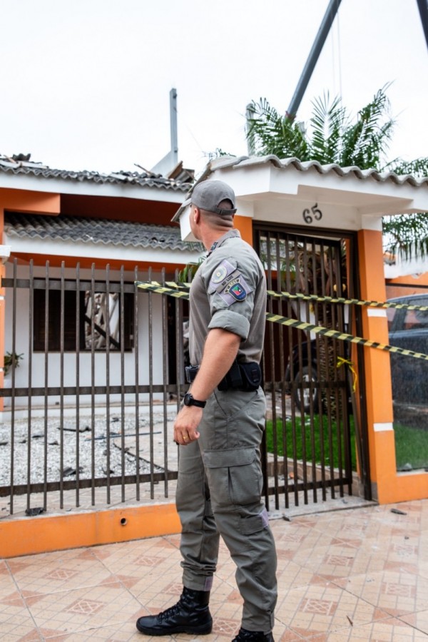 A foto mostra o soldado Luiz em frente a casa destruída