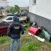 A foto mostra um profissional do Detran fazendo vistoria em desmanche automotivo