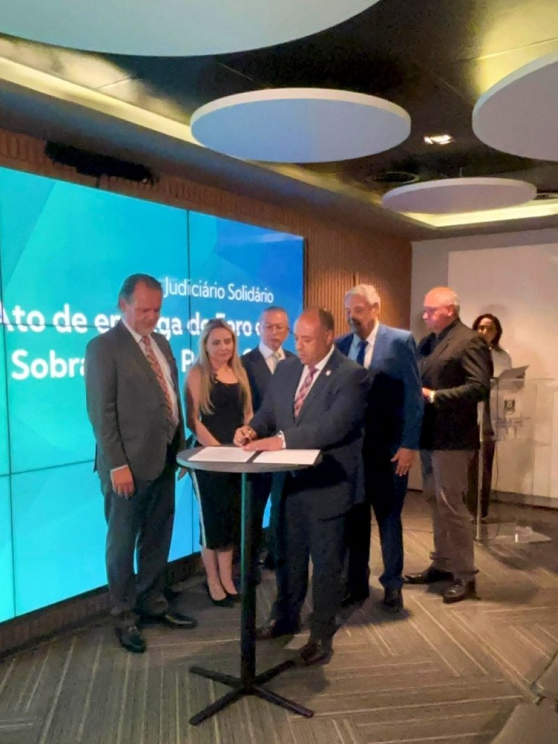 A foto mostra o ato de assinatura do Termo de Entrega de Chaves