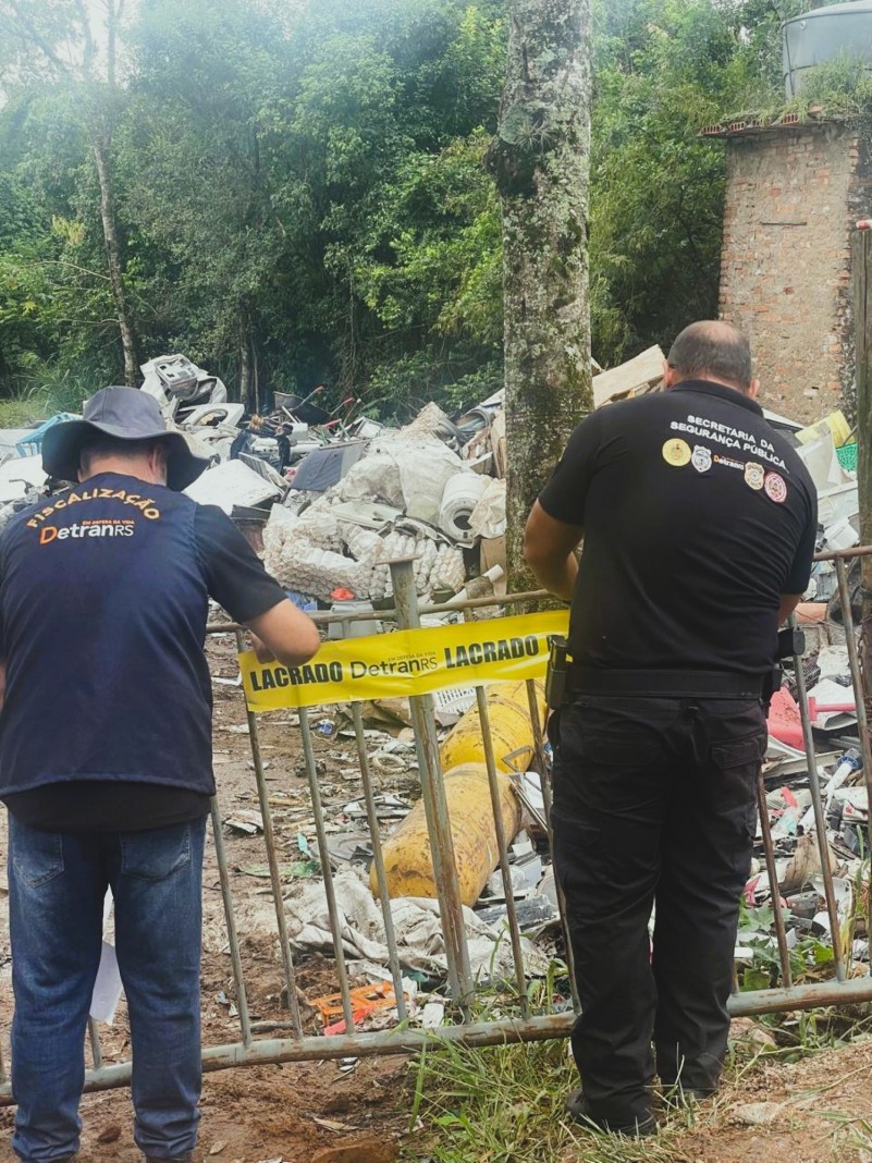 Um agente do Detran e outro da SSP lacrando um local