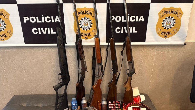 A imagem traz cinco armas longas, munições e outros suprimentos apreendidos