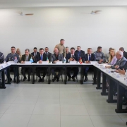 Secretários de Segurança Pública e membros das forças de segurança estão em uma sala. As mesas estão dispostas no formato "U". 